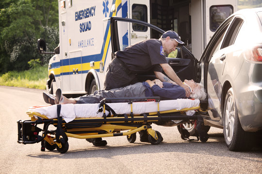 Paramedic putting injured woman on gurney