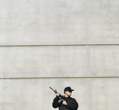Man wearing special forces uniform and holding high powered semi-automatic rifle