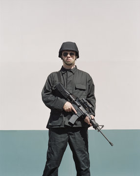 Man wearing special forces uniform and holding high powered semi-automatic rifle