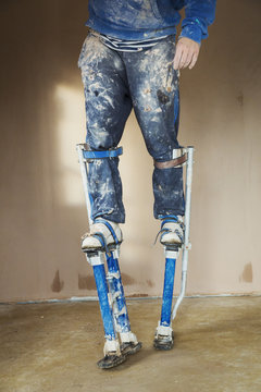 Plasterer wearing stilts