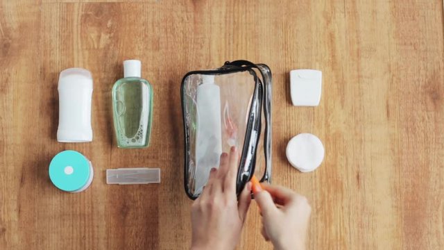 hands packing cosmetic bag for travel