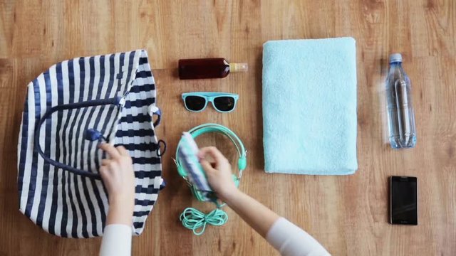hands packing beach accessories to bag