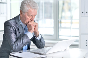 Naklejka premium senior man using laptop 