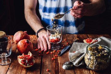 Man Puts Granola into the Glass.