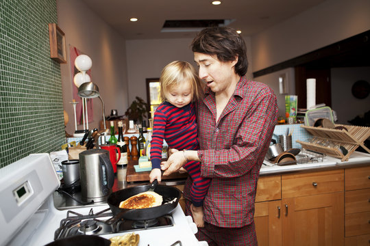 Farther and son ( 2-3 ) making pancakes