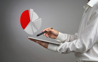 Man in white shirt working with pie chart on a tablet computer, application for budget planning or...
