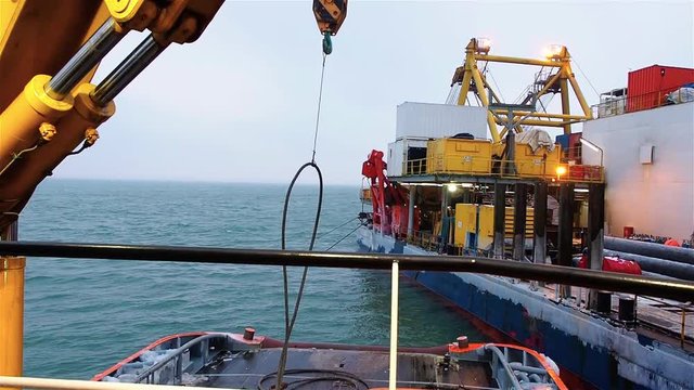Pipelayaer platform crane lifts cable from deck of tug