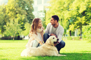 happy couple with labrador dog walking in city