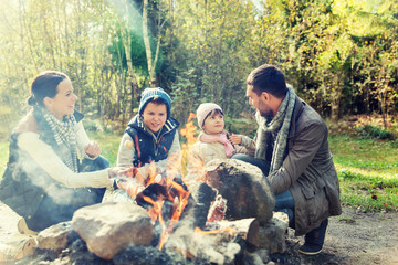 happy family roasting marshmallow over campfire