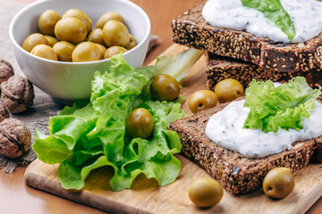 Sandwiches of homemade bread with cheese sauce or cream, lettuce, walnuts, olive