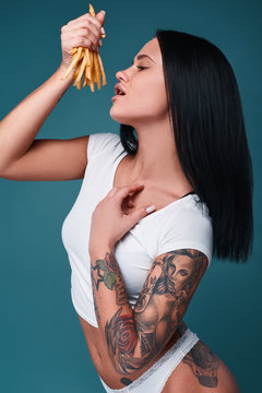 Beautiful charming tattoo girl with french fries