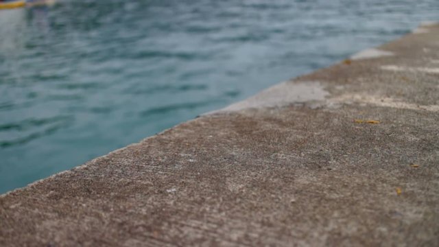 Close up of a concrete dock overlooking the water.