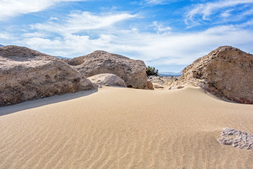 Fototapeta na wymiar Sand dunes, large stones and blue sky