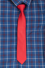 Close up of plaid blue shirt with red necktie