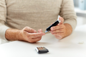 close up of old man with glucometer blood test