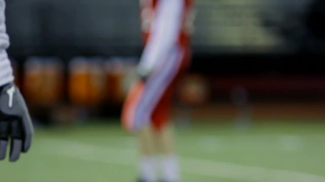 Close up of a quarterback taking a practice snap.