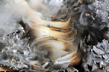 The process of burning paper. A stack of burnt paper with smoke and ash. Close-up.