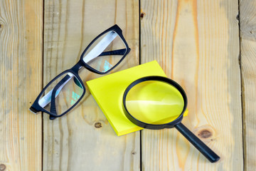 Magnifying glass on yellow sticky note