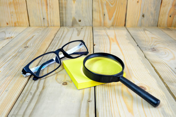 Magnifying glass on yellow sticky note