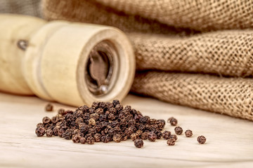 Wooden pepper mill and black peppercorn