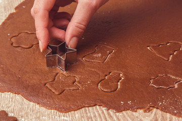 Christmas gingerbread cooking and decoration on the wooden table in the kitchen. Homemade pastries.