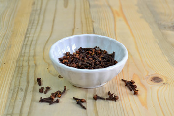 Cloves : Spice in bowl on texture wooden background