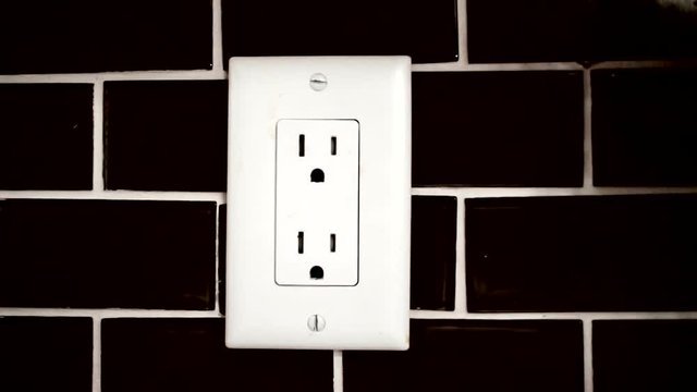 Sequence of an outlet on a wall in black and white.