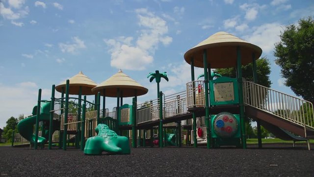 Wide view of a children's playground and a bright sunny day.