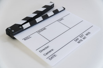 Clapboard on the table from the angle in white background © Mantas