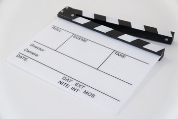 Fototapeta na wymiar Clapboard on the table from the angle in white background