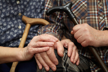 Old couple hands with cane