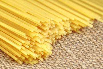 Bunch of Italian spaghetti closeup. Yellow long spaghetti on a rustic background.