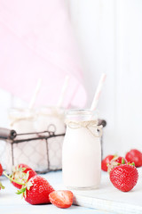 Strawberry yogurt in bottle on wooden table