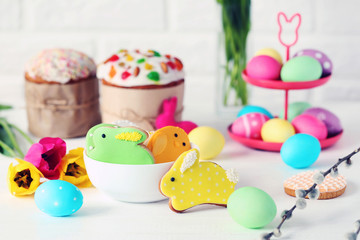 Easter eggs with cookies on a white wooden table