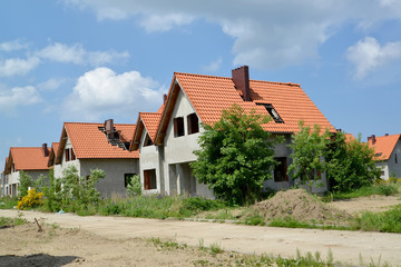 New cottages with tile roofs in the settlement under construction