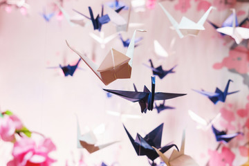 Traditional Japanese origami on strings in the background graphics and sakura - obrazy, fototapety, plakaty