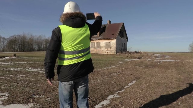 Construction worker take pictures near abandoned house