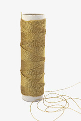 Spool of gold thread. Isolated.