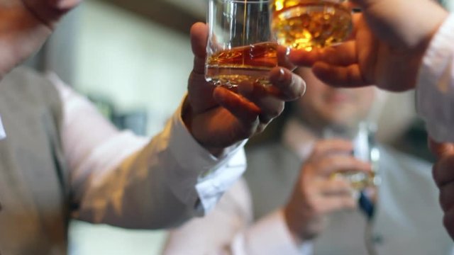 Group of men toasting with glasses of whiskey.