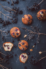 muffin with currants on a dark background next to the berries on the branches. in a rustic style. dark style