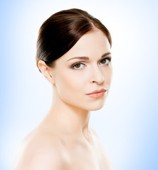 Portrait of young, beautiful and healthy woman: over blue background. Healthcare, spa, makeup and face lifting concept.