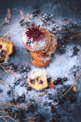 muffin with currants on a dark background next to the berries on the branches. and a bouquet of flowers. in a rustic style. dark style © Mykhailovskyi