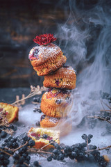 muffin with currants on a dark background. muffins lined tower, for travel along the surface of the smoke. fabulous concept