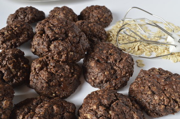 Homemade double chocolate oatmeal cookies with scattered oat flakes and mixer agitator