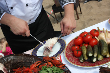 Cooked catfish cutting with crayfishes by a professional cook