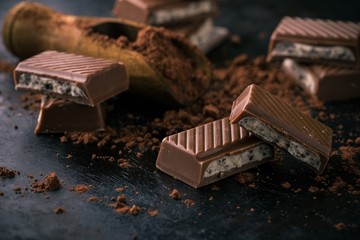 Chocolate with creamy filling on black board with cocoa