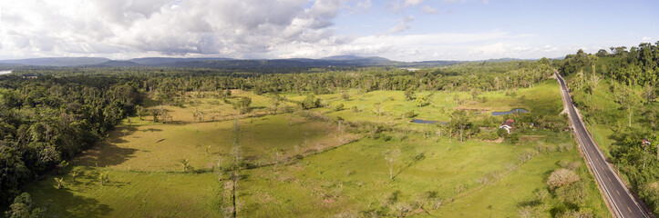 Fototapeta na wymiar Aerial panorama of a cattle farm cleared from lowland tropical rainforest in Ecuador.