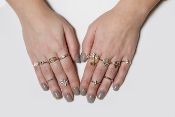 Various gold rings with nice manicured fingernails.