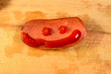 Sausage with ketchup on a wooden table