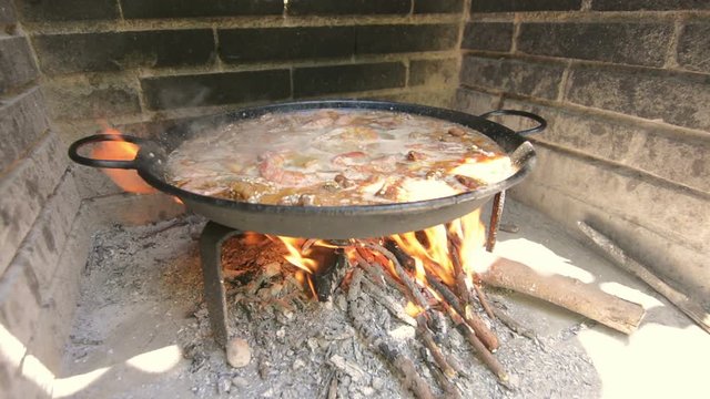 Typical and traditional spanish paella, cooking with natural fire